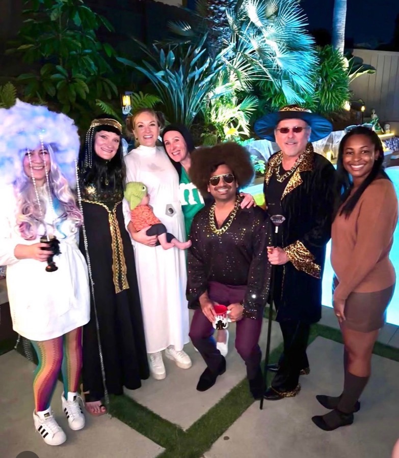 Group cosplay portrait beside a pool at night.